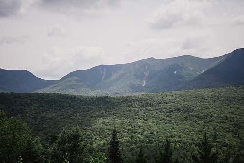 mountain range green and black mountains under white and gray sky at daytime kancamagus pass